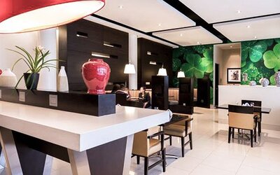 Lobby and reception area at Courtyard Panama Metromall featuring modern furnishings, decorative accents and a green feature wall.