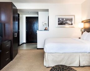 Spacious guest room at Courtyard Panama Metromall featuring a king bed, work area, television and sofa seating.