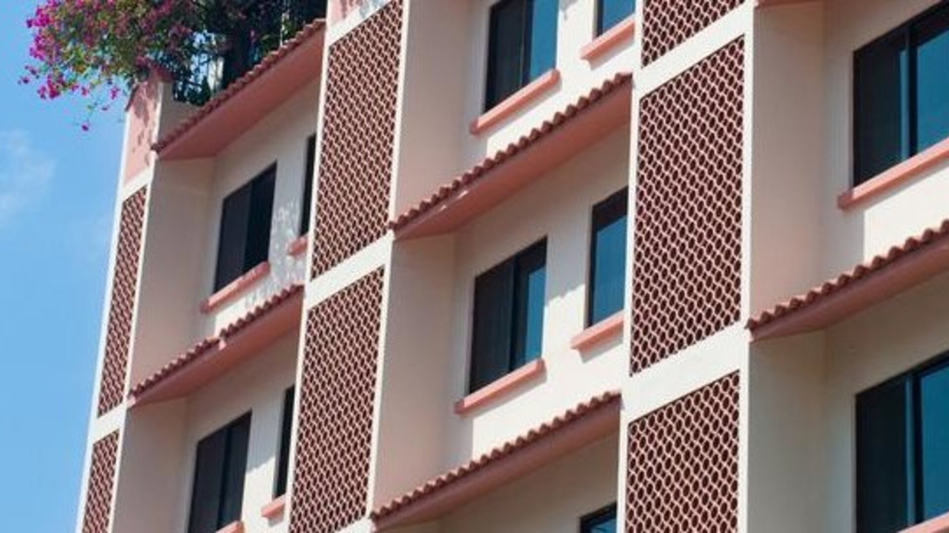 Exterior view of Hotel Benidorm featuring the multi-story hotel building and ground-floor storefronts.