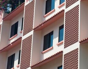 Exterior view of Hotel Benidorm featuring the multi-story hotel building and ground-floor storefronts.