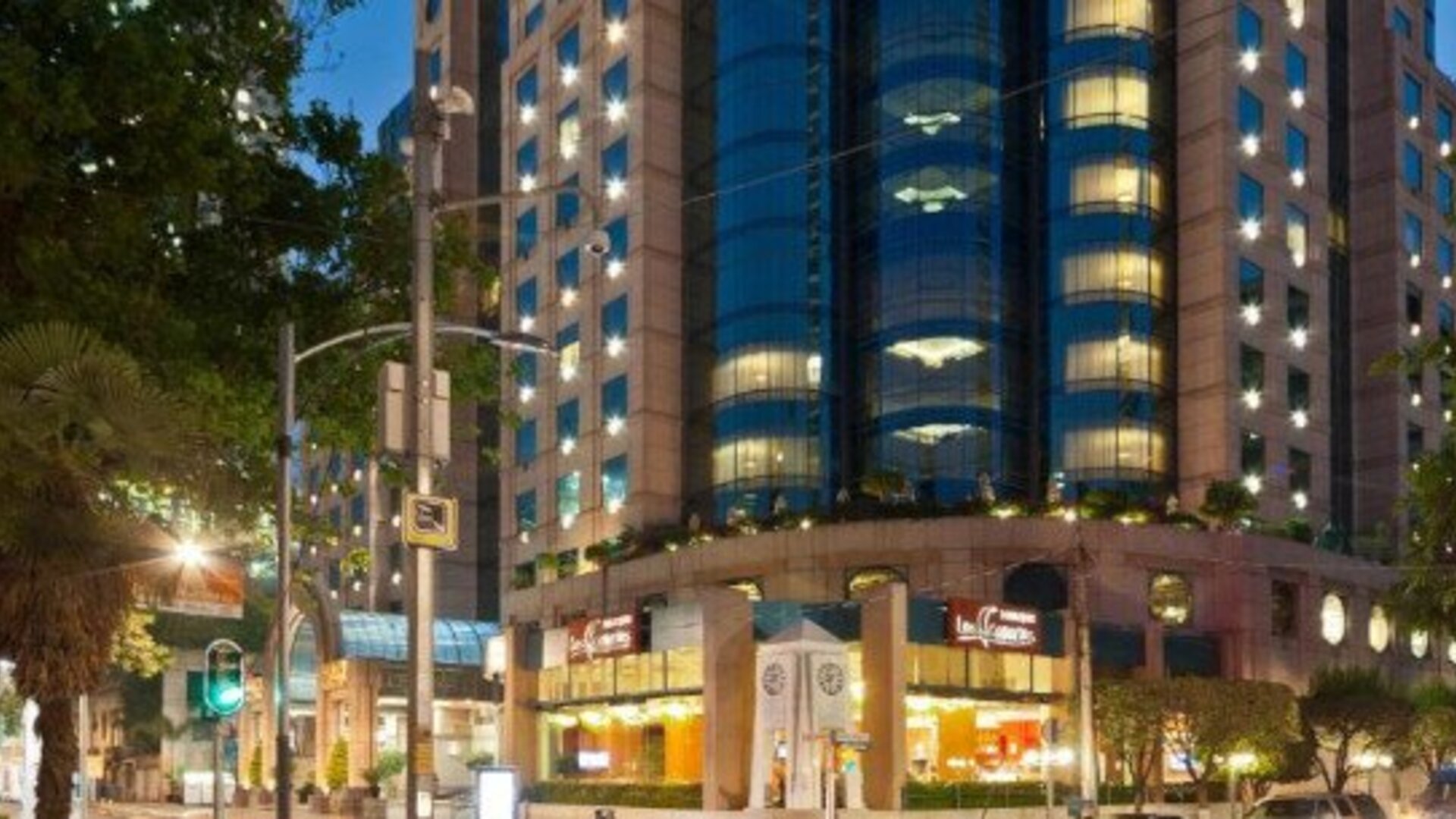 Evening exterior view of Hotel Marquis Reforma with the illuminated hotel façade along the city street.