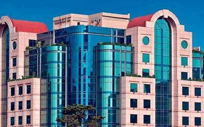Daytime exterior of Hotel Marquis Reforma featuring its distinctive glass and stone façade.