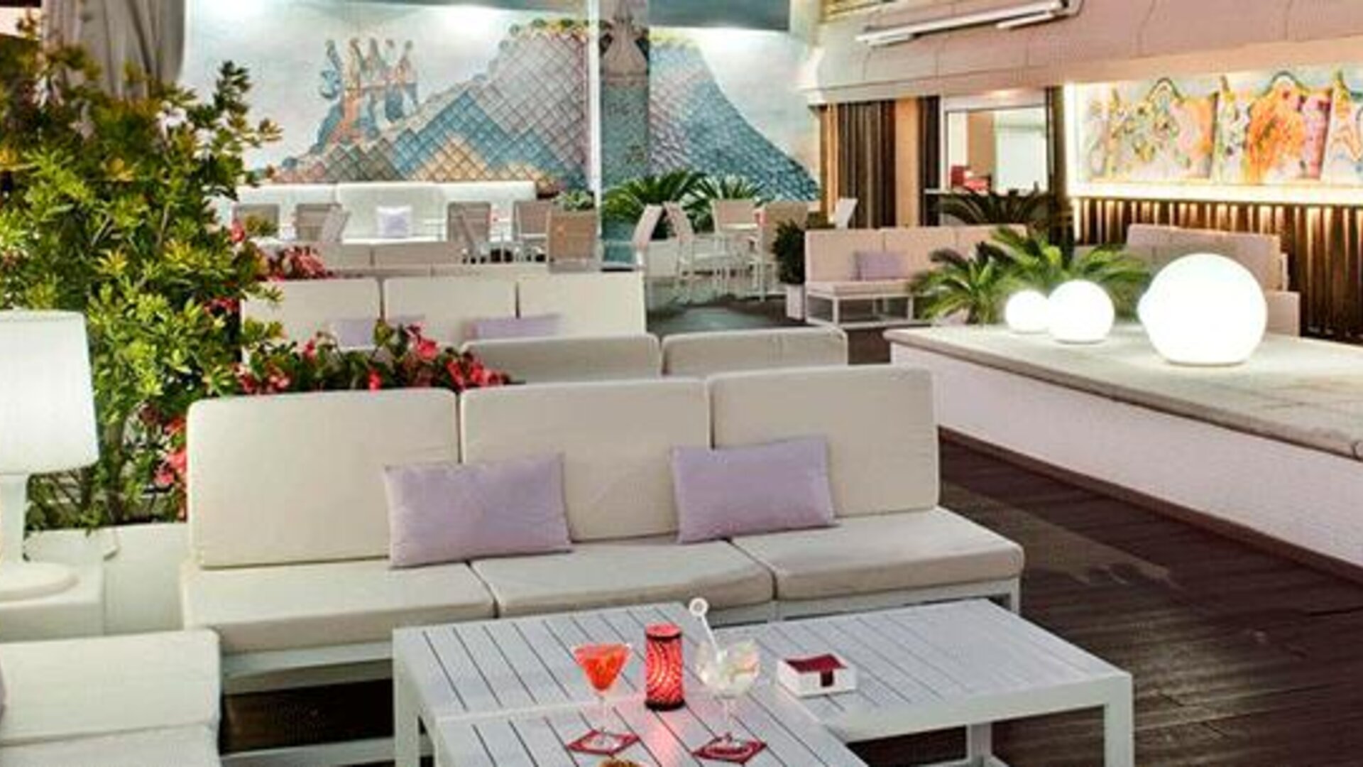 Stylish outdoor terrace featuring lounge seating, greenery and decorative lighting at NH Collection Barcelona Pódium.