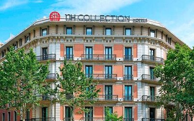 Exterior view of the historic building with balconies and surrounding trees at NH Collection Barcelona Pódium.