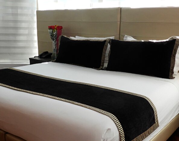 Guest room featuring a king bed, black accent cushions, bedside tables and contemporary lighting at Hotel Airport Travel.