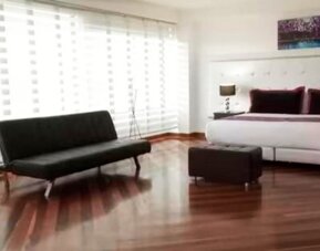 Bright guest room featuring a king bed, large window, city views and contemporary furnishings at Hotel Airport Travel.