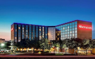 Modern hotel exterior featuring illuminated signage, contemporary architecture and landscaped grounds at Sheraton Houston Brookhollow Hotel.