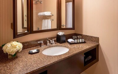 Contemporary bathroom featuring a granite vanity, premium toiletries and framed mirrors at Sheraton Houston Brookhollow Hotel.