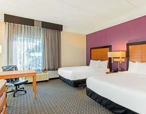 Guest room featuring two double beds, a dedicated workstation and comfortable accommodations for families or groups at La Quinta Inn & Suites By Wyndham Orlando I Drive/Conv Ctr.