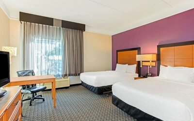 Guest room featuring two double beds, a dedicated workstation and comfortable accommodations for families or groups at La Quinta Inn & Suites By Wyndham Orlando I Drive/Conv Ctr.