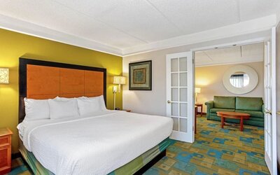 Spacious suite featuring a king-size bed, a separate living area and contemporary furnishings at La Quinta Inn & Suites By Wyndham Orlando I Drive/Conv Ctr.