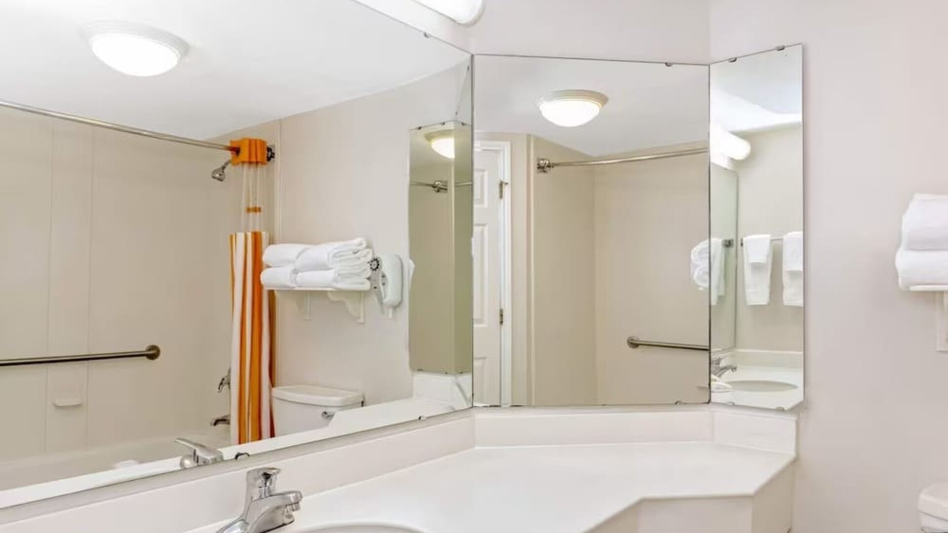 Accessible bathroom featuring a large vanity, safety grab bars and a shower and bathtub combination at La Quinta Inn & Suites By Wyndham Orlando I Drive/Conv Ctr.