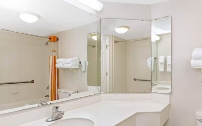 Accessible bathroom featuring a large vanity, safety grab bars and a shower and bathtub combination at La Quinta Inn & Suites By Wyndham Orlando I Drive/Conv Ctr.