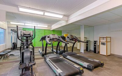 Fitness center featuring treadmills, an elliptical machine and cardio equipment for convenient workouts at La Quinta Inn & Suites By Wyndham Orlando I Drive/Conv Ctr.