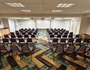 Meeting room featuring theater-style seating, presentation facilities and flexible event space at La Quinta Inn & Suites By Wyndham Orlando I Drive/Conv Ctr.