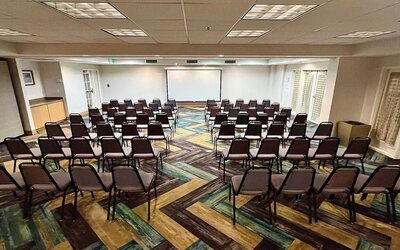 Meeting room featuring theater-style seating, presentation facilities and flexible event space at La Quinta Inn & Suites By Wyndham Orlando I Drive/Conv Ctr.