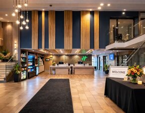 Modern hotel lobby featuring a spacious reception area, contemporary décor and comfortable gathering spaces at Holiday Inn Toronto Airport East.