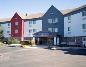 Modern bathroom featuring a spacious vanity, illuminated mirror and a glass-enclosed shower at Candlewood Suites Boise.