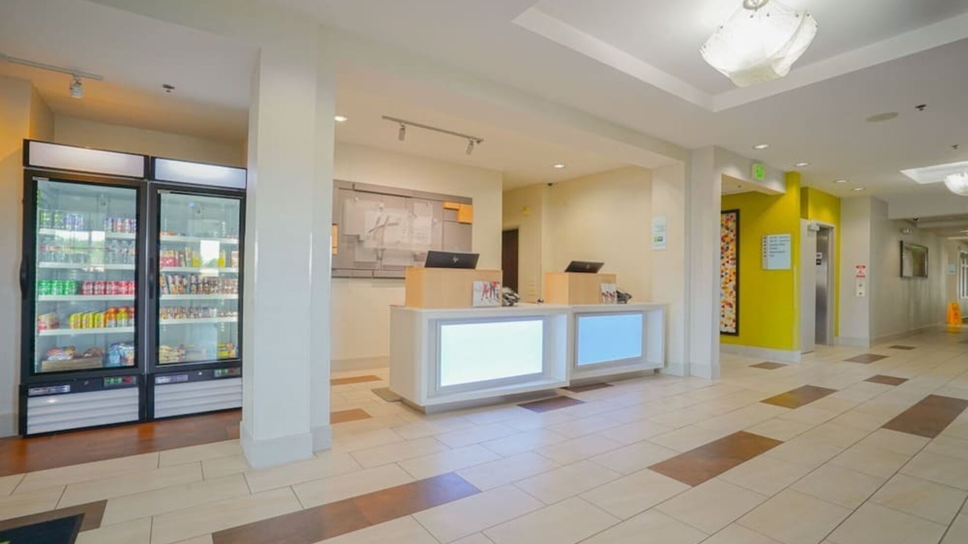 Reception area featuring a modern front desk, a grab-and-go market and bright, welcoming décor at Holiday Inn Express & Suites Ontario.