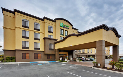 Hotel exterior featuring a covered entrance, contemporary architecture and convenient on-site parking at Holiday Inn Express SFO Airport North.
