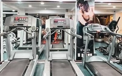 Fitness center equipped with treadmills, elliptical machines, cardio equipment, mirrors, and exercise stations at Hotel Geneve.