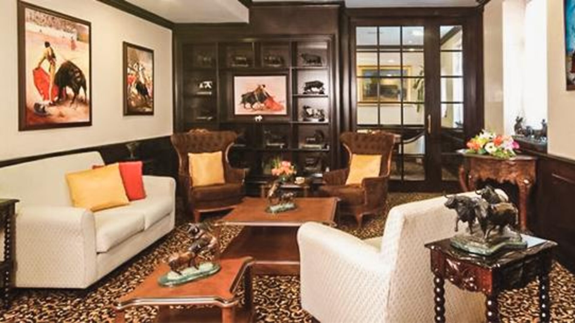 Private lounge featuring sofas, armchairs, handcrafted furnishings, artwork, and traditional Mexican-inspired décor at Hotel Geneve.