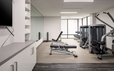 Fitness center featuring strength-training equipment, free weights, and a bright, modern workout space at Houston Marriott South at Hobby Airport.