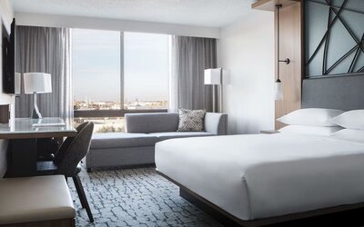 Guest room featuring a chaise lounge, city views, a workspace, and contemporary furnishings at Houston Marriott South at Hobby Airport.