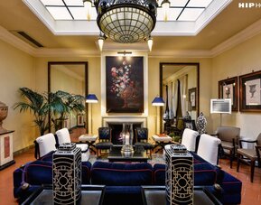 Lobby lounge featuring a decorative fireplace, classic furnishings, artwork, and sophisticated Italian-inspired décor at Cellai Boutique Hotel.