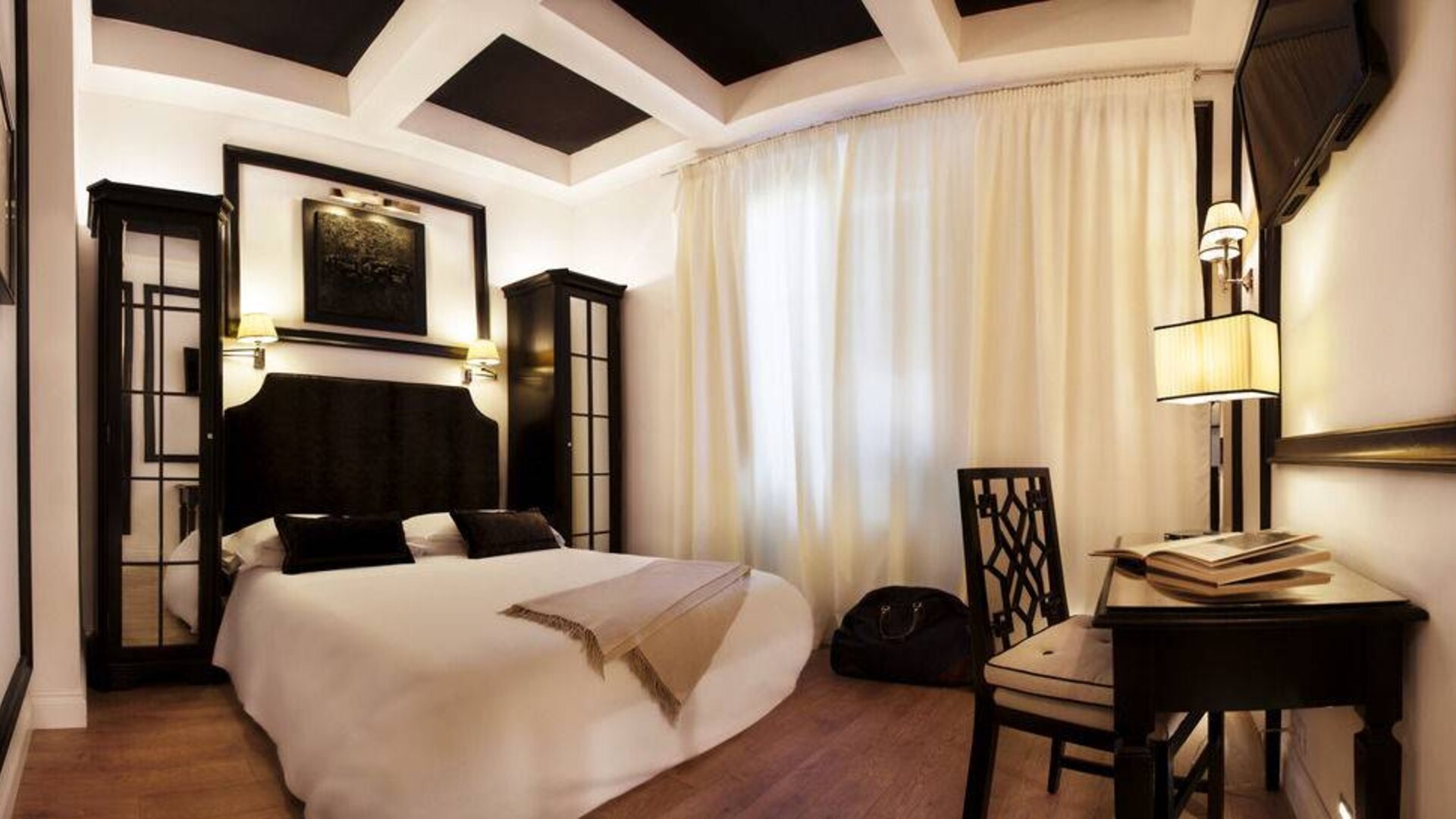 Spacious king room featuring coffered ceilings, a writing desk, contemporary lighting, and refined décor at Cellai Boutique Hotel.