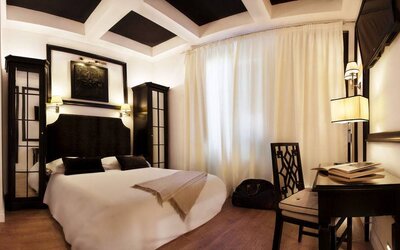 Spacious king room featuring coffered ceilings, a writing desk, contemporary lighting, and refined décor at Cellai Boutique Hotel.