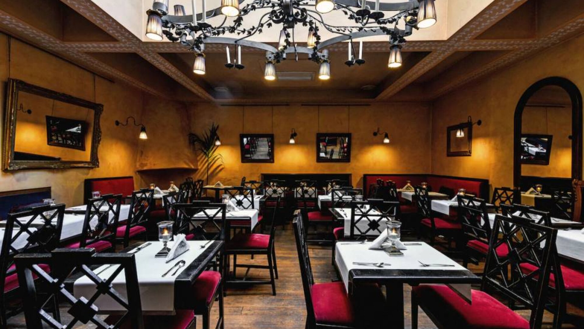 Restaurant featuring elegant chandeliers, upholstered seating, intimate dining tables, and warm ambient lighting at Cellai Boutique Hotel.