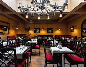 Restaurant featuring elegant chandeliers, upholstered seating, intimate dining tables, and warm ambient lighting at Cellai Boutique Hotel.