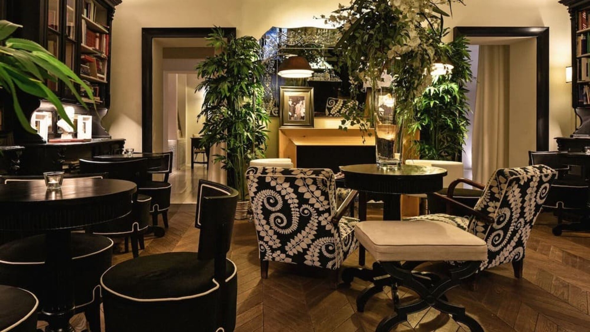 Lobby area featuring decorative floral arrangements, library-style shelving, patterned seating, and an intimate atmosphere at Cellai Boutique Hotel.