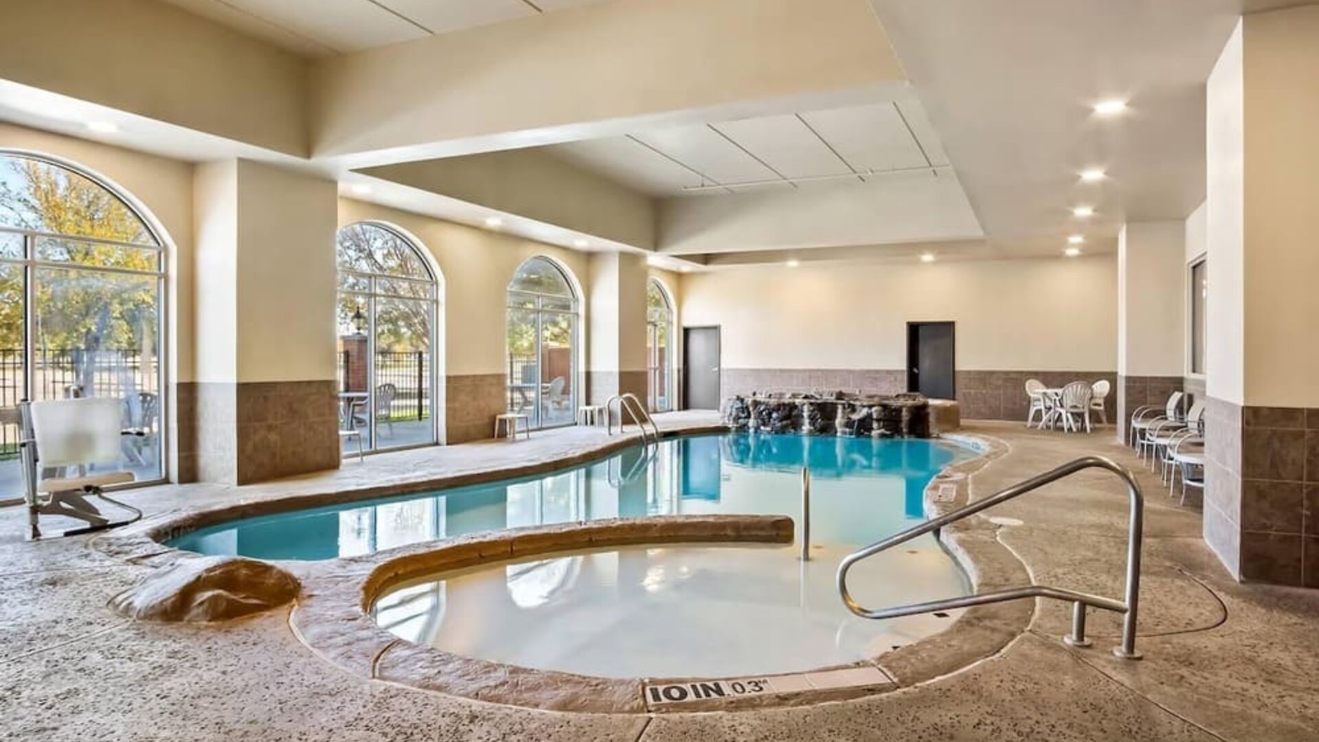 Alternate view of the indoor pool area highlighting the accessible lift, spa, and lounge seating at Comfort Suites Frisco.