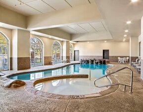Alternate view of the indoor pool area highlighting the accessible lift, spa, and lounge seating at Comfort Suites Frisco.