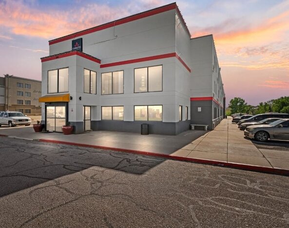 Exterior view of Coratel Inn And Suites By Jasper Wichita North with parking area.