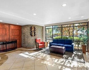 Bright lobby seating area with comfortable sofas, armchairs, large windows, and contemporary décor at Comfort Suites Vacaville-Napa Valley Area.