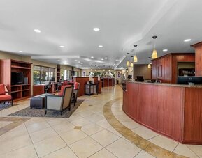 Spacious reception and lobby area featuring the front desk, guest seating, and warm pendant lighting at Comfort Suites Vacaville-Napa Valley Area.
