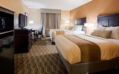 Guest room featuring two beds, flat-screen television, workspace, microwave, and mini refrigerator at Best Western Granbury Inn & Suites.