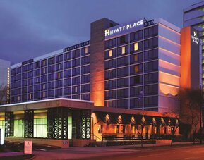 Exterior view of the multi-storey hotel illuminated in the evening at Hyatt Place San Jose Downtown.