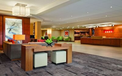 Spacious reception and lobby area featuring contemporary seating, colourful furnishings, artwork, and a front desk at Hyatt Place San Jose Downtown.
