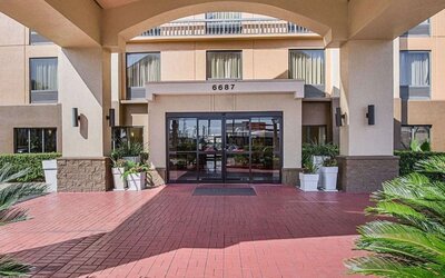 Covered front entrance featuring landscaped surroundings and glass entry doors at Comfort Inn Southwest At Westpark.