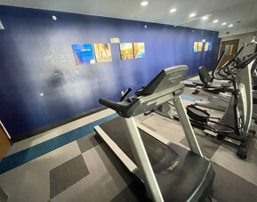Fitness centre with treadmill, elliptical machines, exercise bike, and mirrored wall at Comfort Suites San Antonio SeaWorld - Lackland AFB.