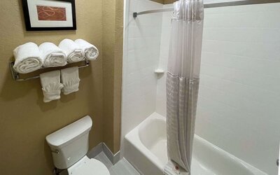 Guest bathroom vanity with two sinks, illuminated mirror, granite countertop, toiletries, and hair dryer at Comfort Suites San Antonio SeaWorld - Lackland AFB.