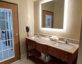Guest bathroom with bathtub and shower, toilet, fresh towels, and tiled surround at Comfort Suites San Antonio SeaWorld - Lackland AFB.