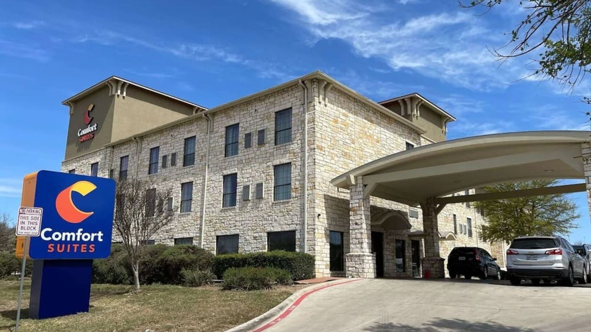 Exterior view of Comfort Suites San Antonio SeaWorld - Lackland AFB, featuring the stone façade, hotel signage, and covered entrance.
