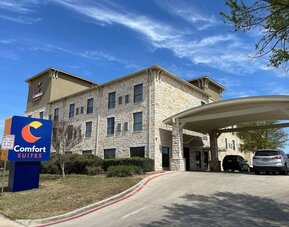 Exterior view of Comfort Suites San Antonio SeaWorld - Lackland AFB, featuring the stone façade, hotel signage, and covered entrance.