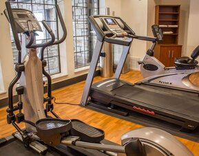 Fitness centre with treadmill, elliptical trainer, exercise bike, and large windows at Comfort Suites San Antonio SeaWorld - Lackland AFB.