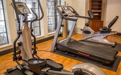 Fitness centre with treadmill, elliptical trainer, exercise bike, and large windows at Comfort Suites San Antonio SeaWorld - Lackland AFB.